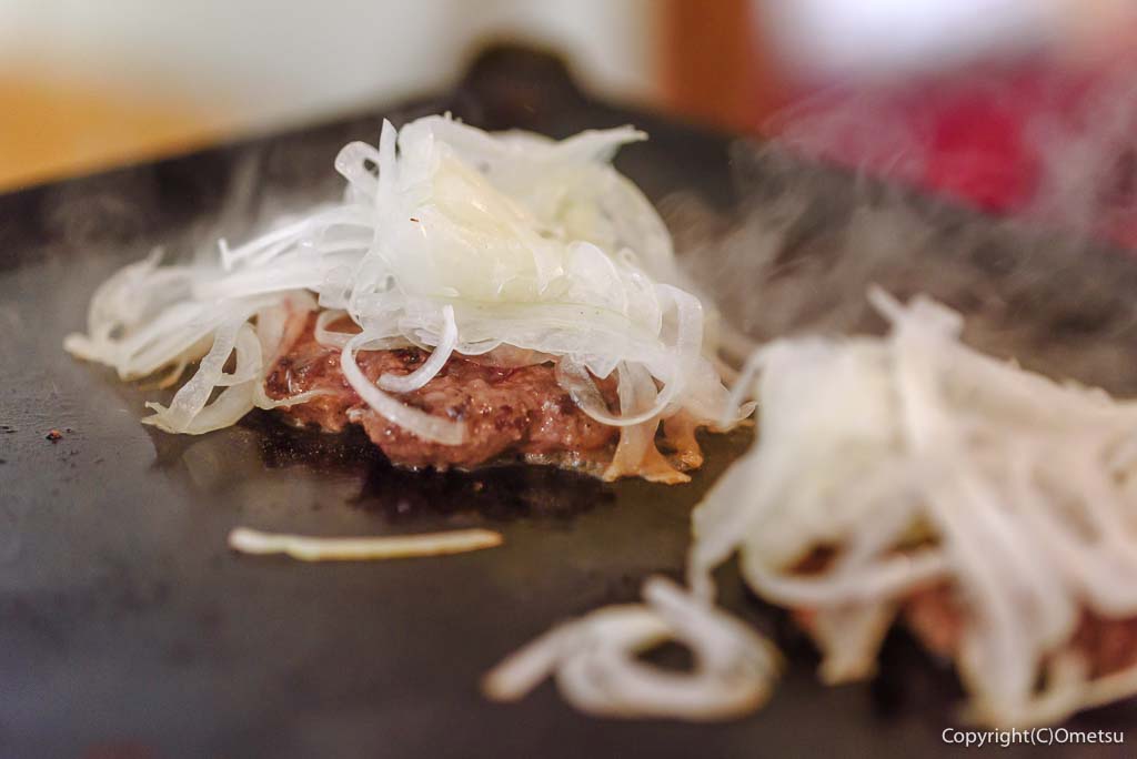 「青梅スマッシュバーガー杉屋」の、鉄板で焼くハンバーグと、タマネギ